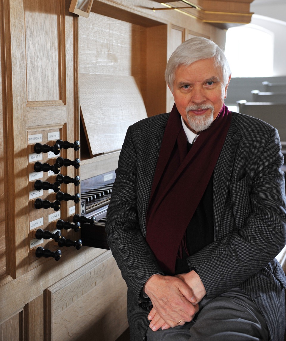 Der elegante Senior Harald Vogel posiert vor einer Orgel